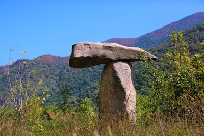 在绿色草地上的灰色岩层白天
